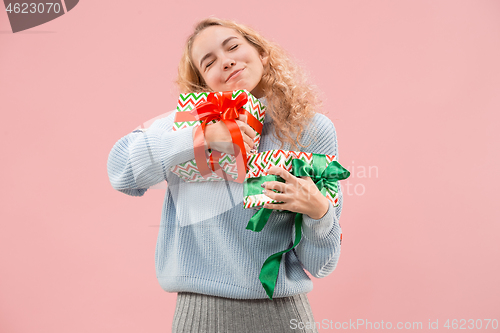 Image of Woman with big beautiful smile holding colorful gift boxes.