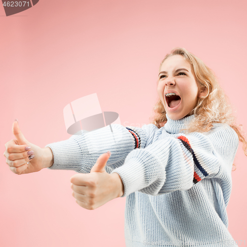 Image of The happy business woman standing and smiling against pink background.