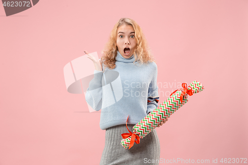 Image of Woman with big beautiful smile holding colorful gift box.