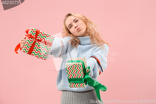 Image of Woman with big beautiful smile holding colorful gift boxes.