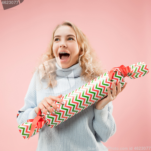 Image of Woman with big beautiful smile holding colorful gift box.