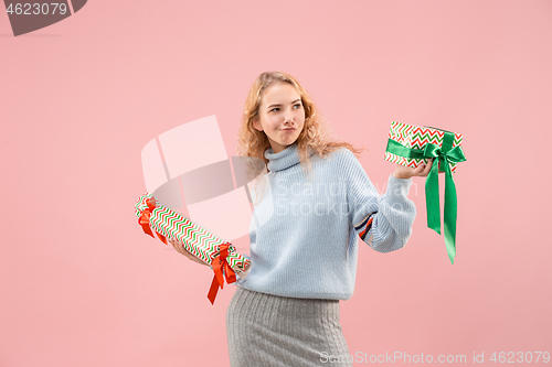 Image of Woman with big beautiful smile holding colorful gift boxes.