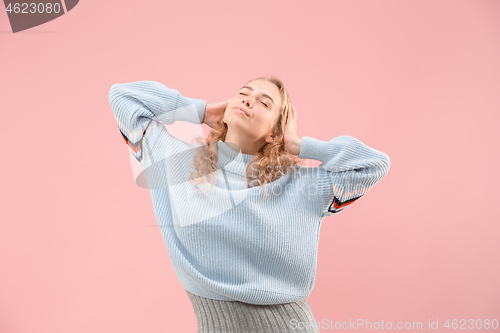 Image of The happy business woman standing and smiling against pink background.