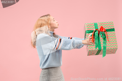 Image of Woman with big beautiful smile holding colorful gift box.