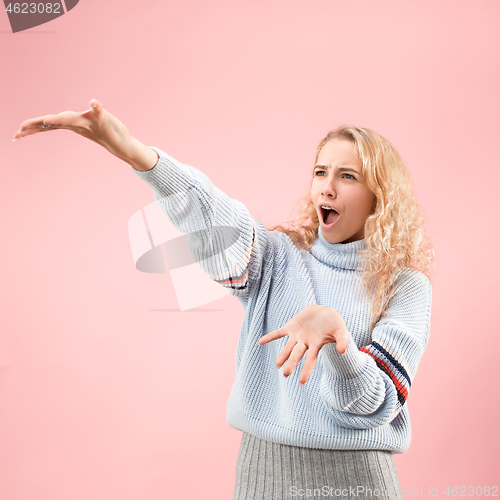 Image of Beautiful woman looking suprised isolated on pink