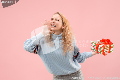 Image of Woman with big beautiful smile holding colorful gift box.