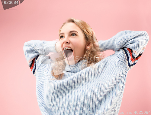 Image of Beautiful woman looking suprised isolated on pink