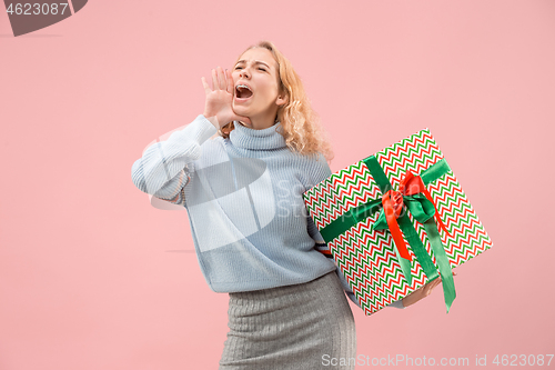 Image of Woman with big beautiful smile holding colorful gift box.