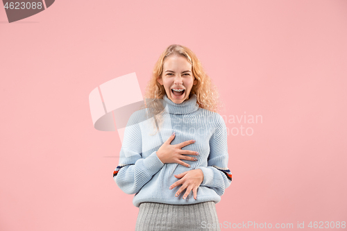 Image of The happy business woman standing and smiling against pink background.