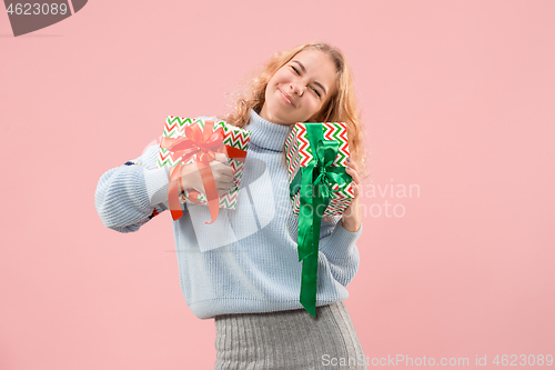 Image of Woman with big beautiful smile holding colorful gift boxes.