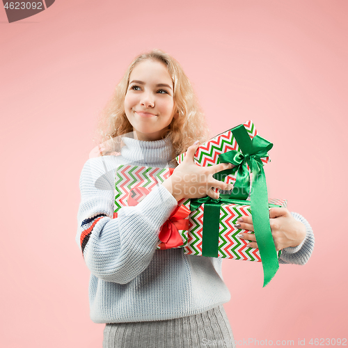 Image of Woman with big beautiful smile holding colorful gift boxes.