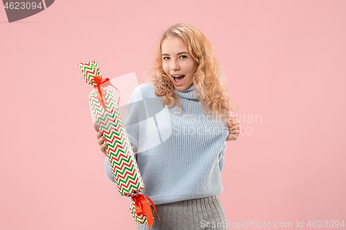 Image of Woman with big beautiful smile holding colorful gift box.