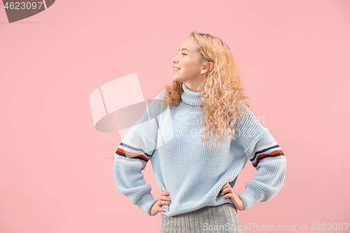 Image of The happy business woman standing and smiling against pink background.