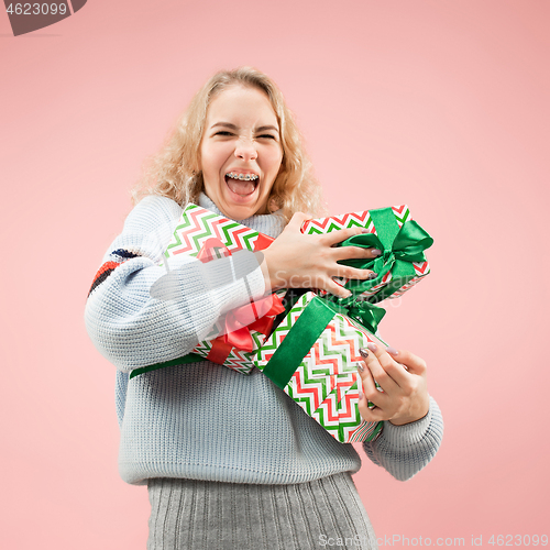 Image of Woman with big beautiful smile holding colorful gift boxes.