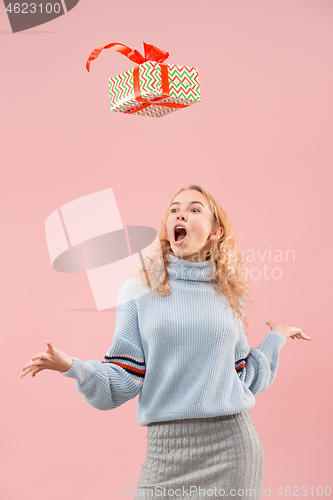 Image of Woman with big beautiful smile holding colorful gift box.