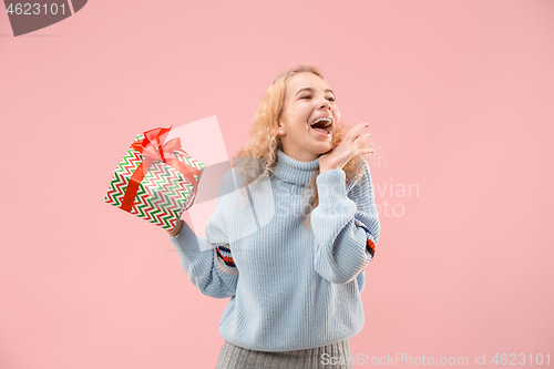 Image of Woman with big beautiful smile holding colorful gift box.
