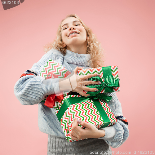 Image of Woman with big beautiful smile holding colorful gift boxes.