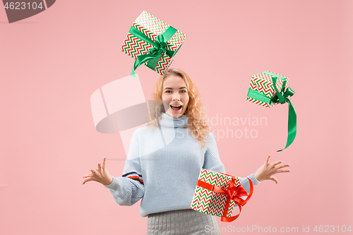 Image of Woman with big beautiful smile holding colorful gift boxes.