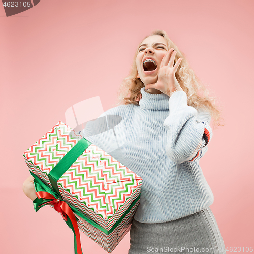 Image of Woman with big beautiful smile holding colorful gift box.