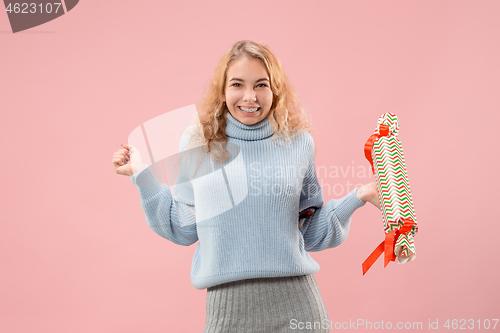 Image of Woman with big beautiful smile holding colorful gift box.