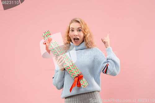 Image of Woman with big beautiful smile holding colorful gift box.