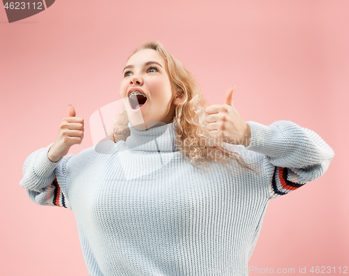 Image of The happy business woman standing and smiling against pink background.