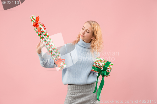 Image of Woman with big beautiful smile holding colorful gift boxes.