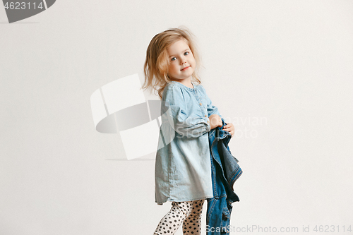 Image of Full length portrait of cute little kid in stylish jeans clothes looking at camera and smiling