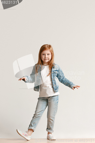 Image of Full length portrait of cute little kid in stylish jeans clothes looking at camera and smiling