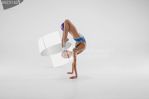Image of The teenager girl doing gymnastics exercises isolated on white background