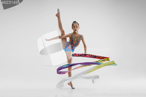 Image of The portrait of beautiful young brunette woman gymnast training calilisthenics exercise with ribbon