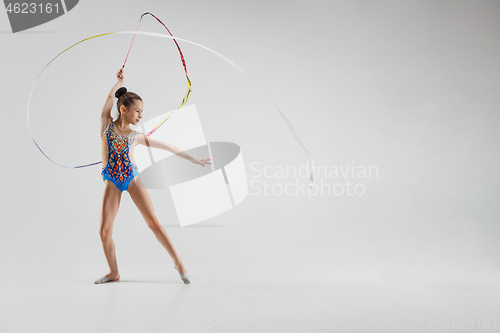 Image of The portrait of beautiful young brunette woman gymnast training calilisthenics exercise with ribbon