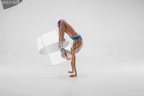 Image of The teenager girl doing gymnastics exercises isolated on white background