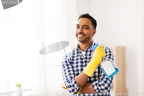 Image of smiling indian man with detergent cleaning at home