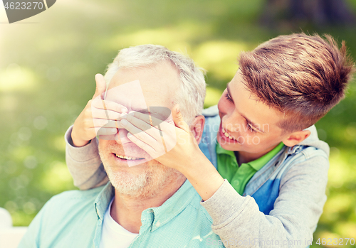 Image of grandfather and grandson playing at summer park