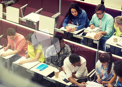 Image of group of students with notebooks at lecture hall