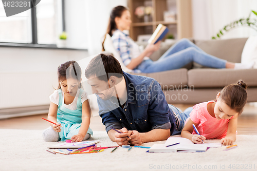 Image of father with little daughters drawing at home