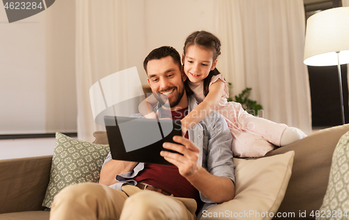 Image of father and daughter with tablet computer at home