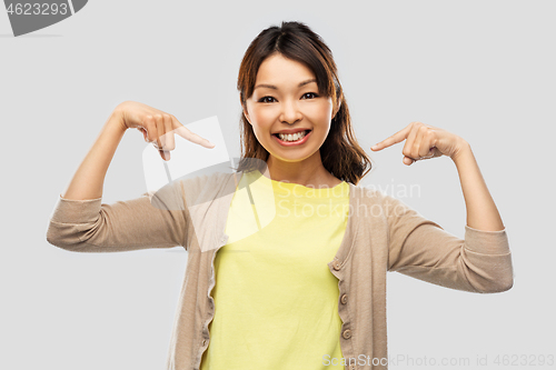 Image of happy asian woman over grey background