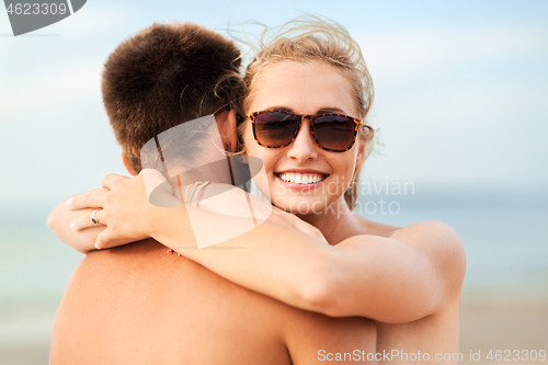 Image of happy couple hugging on summer beach