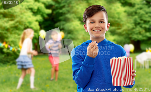 Image of smiling boy eating popcorn at birthday party