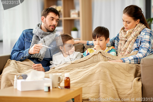 Image of family with ill children having fever at home