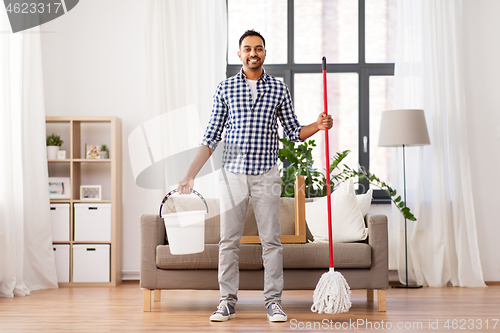 Image of indian man with mop and bucket cleaning at home