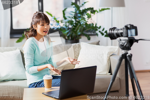 Image of asian female blogger with camera recording video