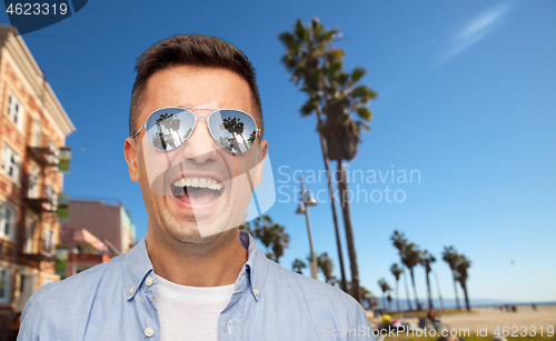 Image of laughing man in sunglasses over venice beach