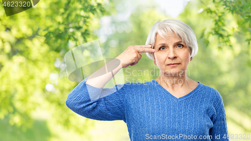 Image of senior woman making finger gun gesture