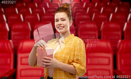 Image of redhead teenage girl with popcorn at movie theater