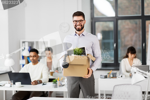 Image of happy male office worker with personal stuff