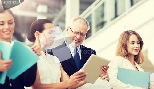 Image of business team with tablet pc and folders at office