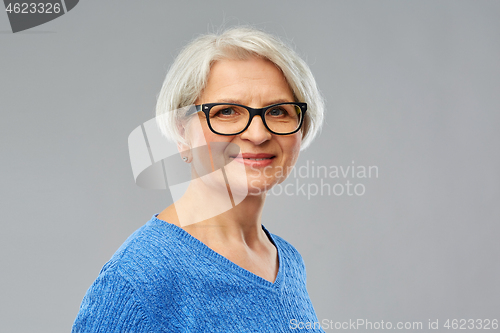 Image of portrait of senior woman in glasses over grey